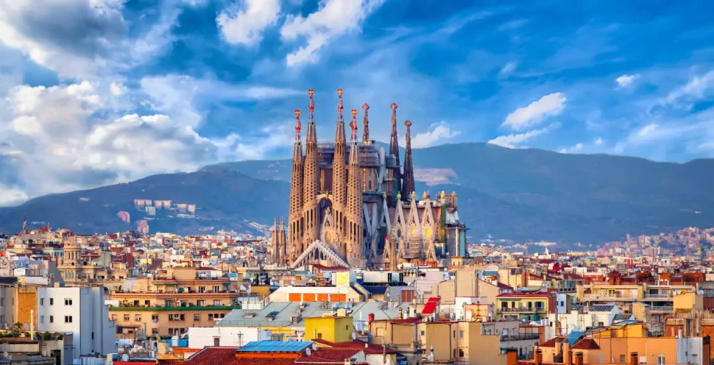 Sagrada Família überragt die Dächer Barcelonas, Spanien, unter dramatischem Wolkenhimmel
